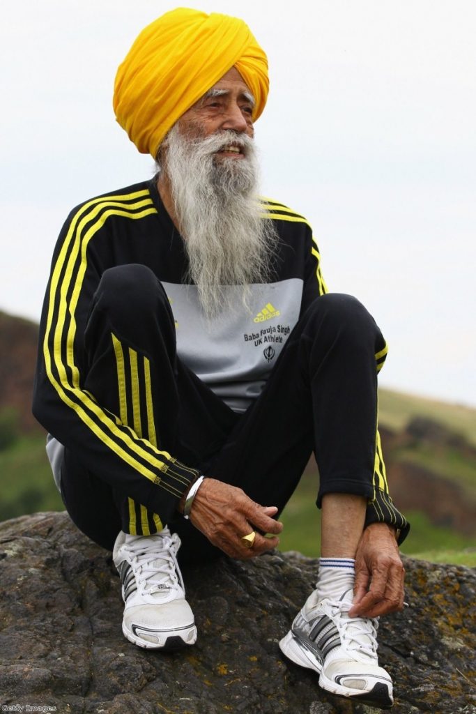 One hundred year old runner Fauja Singh, a Sikh, poses for pictures after being the first person to enter for 2012