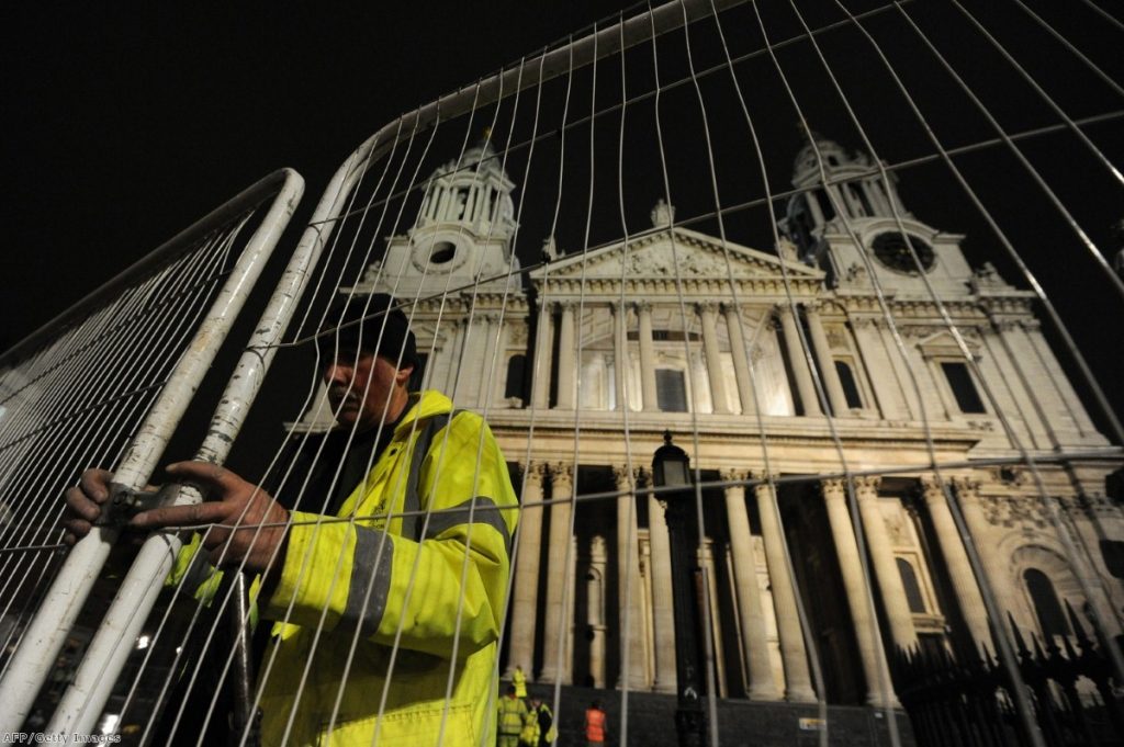 A worker erects a fence near Saint Paul's after police and bailiffs evicted protesters.