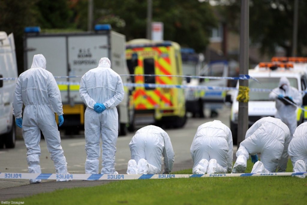 Forensic officers search the scene outside a house in Hattersley, Tameside where two female police officers were shot today