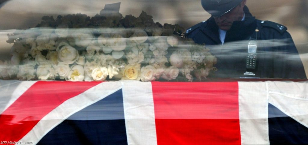 A policeman lowers his head as Margaret Thatcher is brought to parliament yesterday.