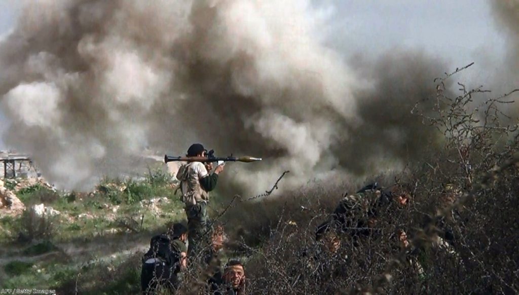 An opposition fighter holding a rocket propelled grenade (RPG) as his fellow comrades take cover from an attack by regime forces in Khanasser on Monday  