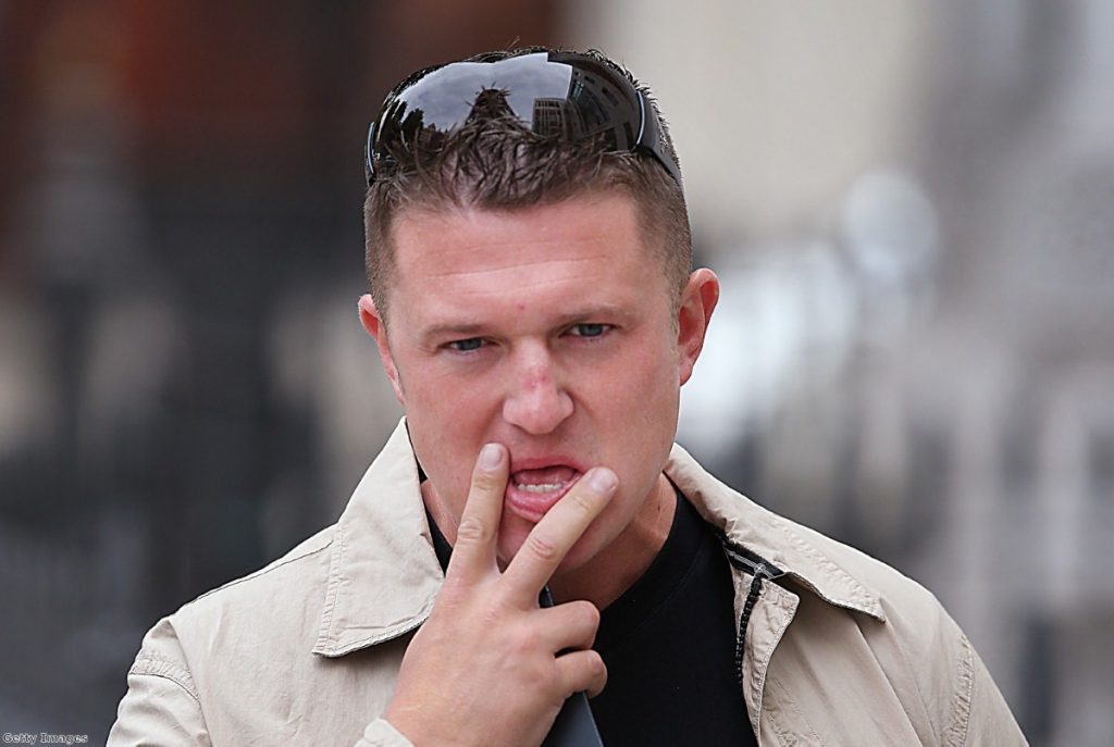 Robinson poses for the cameras after attending Westminster Magistrates Court 