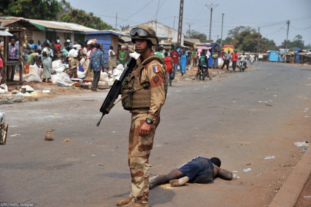 A French soldier stands by the body of a Muslim man who was reportedly beaten to death by a crowd in the north of Bangui last Friday.