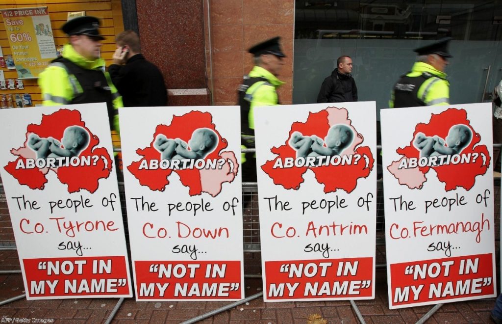 Police walk around anti-abortion placards outside the Marie Stopes clinic, the first private clinic to offer abortions to women in Belfast. 