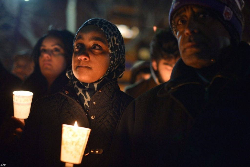 People hold candles during a vigil for three young Muslims killed in Chapel Hill, North Carolina, last night in Washington 