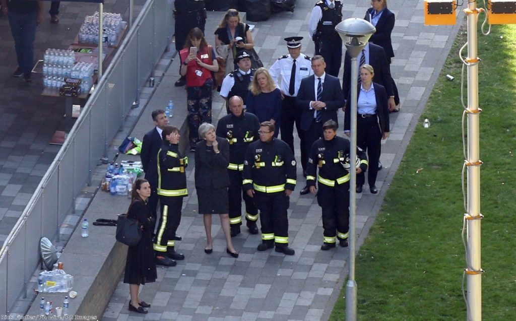 "Theresa May speaks with London Fire Commissioner Dany Cotton as she visits the scene near Grenfell Tower" 