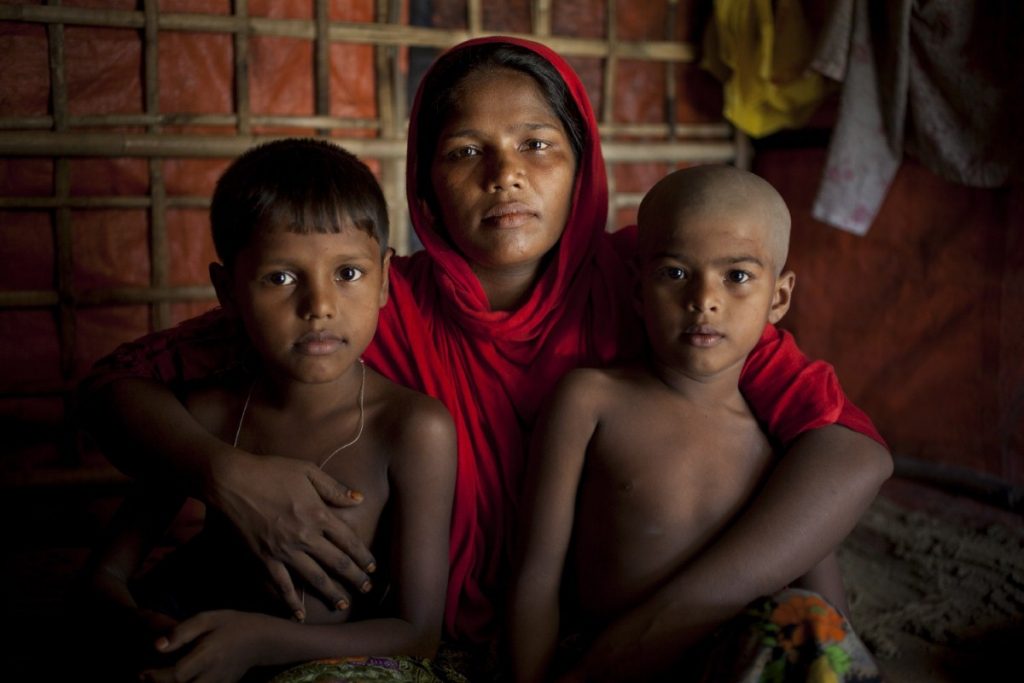 A Rohingya refugee cuddles her children in the camps in Cox