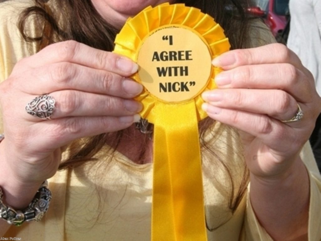 A supporter holds up a Lib Dem rosette mocking Gordon Brown