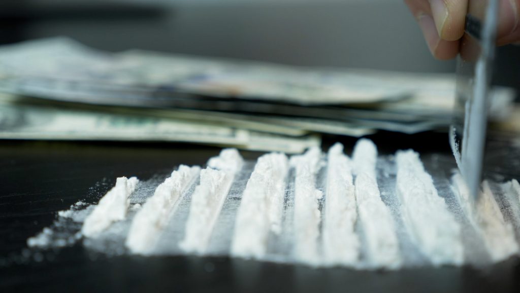 A white powder being cut up with a credit card